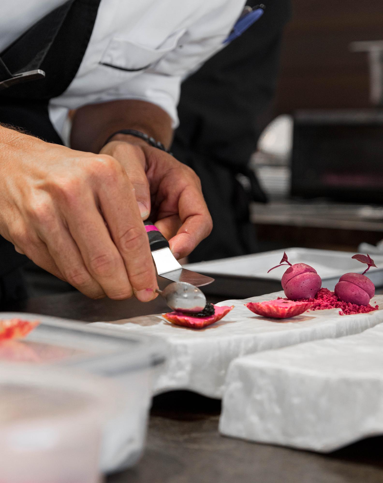 Instructor demonstrating knife technique in professional kitchen